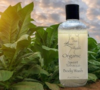 a bottle of organic tobacco body wash in a field